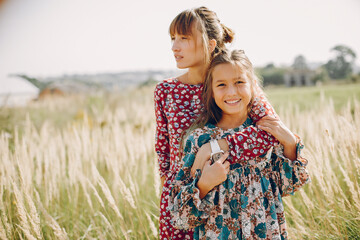 Fashionable mother with daughter. Family in a summer fiels. Girl in a red dress.