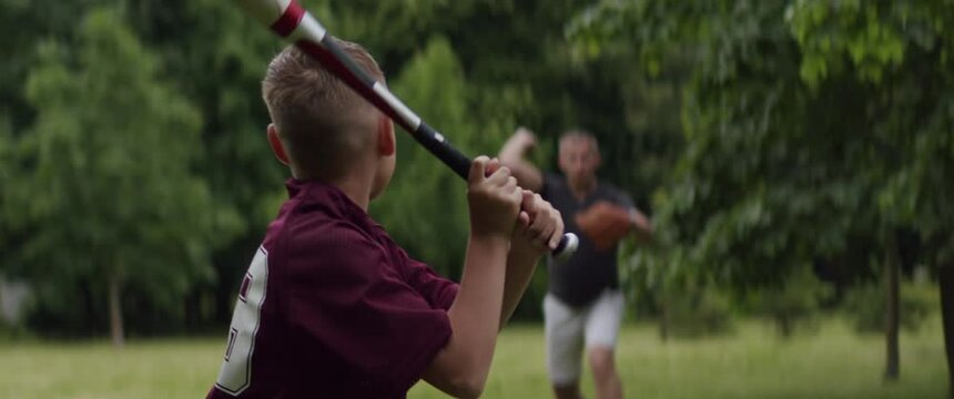 MED Father and son playing baseball in the park on a rainy day. Family time spent together. Shot with 2x Anamorphic lens