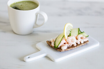 shrimp and cucumber open sandwich on marble background with copy space