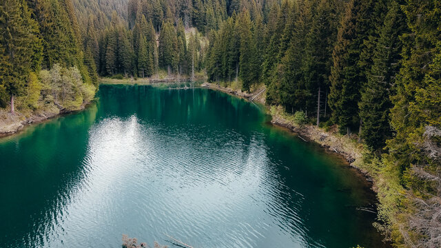 Aerial view over forest and lake in Bucegi Mountains, Romania.