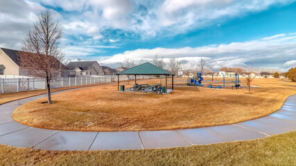 Obraz premium Panorama Neighborhood landscape with recreational park and homes under blue cloudy sky
