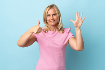 Fototapeta premium Middle age woman isolated on blue background counting six with fingers