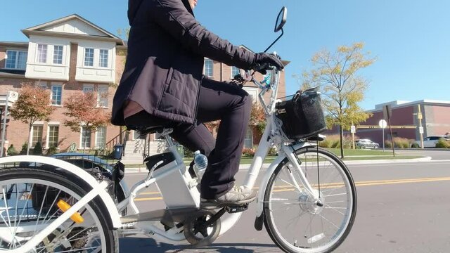 Riding electric bicycle on the city streets at sunny day. Camera view to the power batteries and electro motor. Natural lighting. The view of the power battery of e bike. Leisure lifestyle.