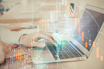 Double exposure of stock market graph with man working on laptop on background. Concept of financial analysis.