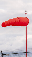 Vertical Red wind sock at an airport blowing in the wind
