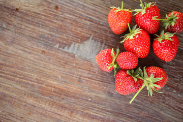 Close up view of fresh strawberries and raspberries on a cutting board. Selected focus, space for text.