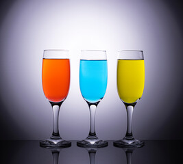 Colored wines in champagne glasses on a beautiful diffuse background