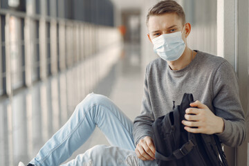 Man at the hall. Person in a grey sweater. Coronavirus theme. Guy in a mask.