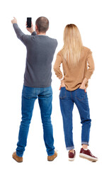 Back view of couple in sweater with mobile phone.