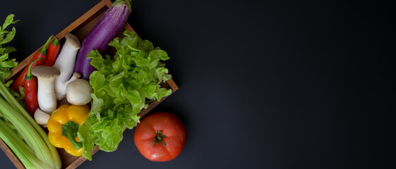 Dark kitchen table with copy space and basket of assorted fresh vegetables