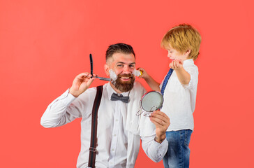 Shaving in barbershop. Beard care. Little barber. Barbershop advertising. Salon for men. Son and dad in barber shop. Assistant for dad. Fathers day.