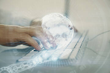 Double exposure of world map hologram with man working on computer on background. Concept of worldwideweb.