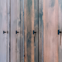 Square Close up of dark brown wooden doors of a cabinet with black handles