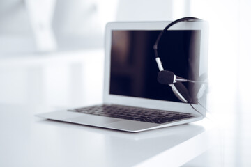 Call center and communication support, customer service help desk. VOIP headset on laptop computer