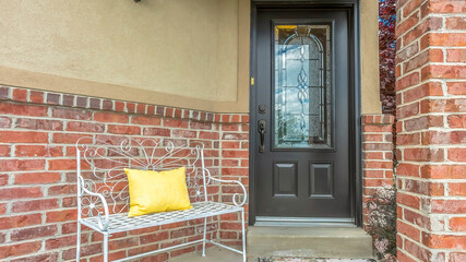 Panorama frame Front door with decorative glass pane at the facade of home with red brick wall