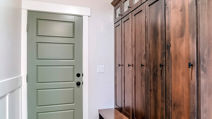 Panorama Panelled fire door with black knobs and lock adjacent to a tall vintage cabinet