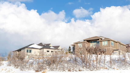 Fototapeta na wymiar Panorama crop Sunny town situated on the snow covered slope of Wasatch Mountains in winter