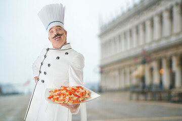 Chef cook with a fast food on a plate on a street city