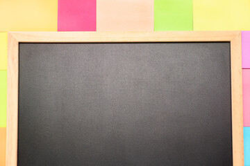 Empty blackboard and coloured post-it on it