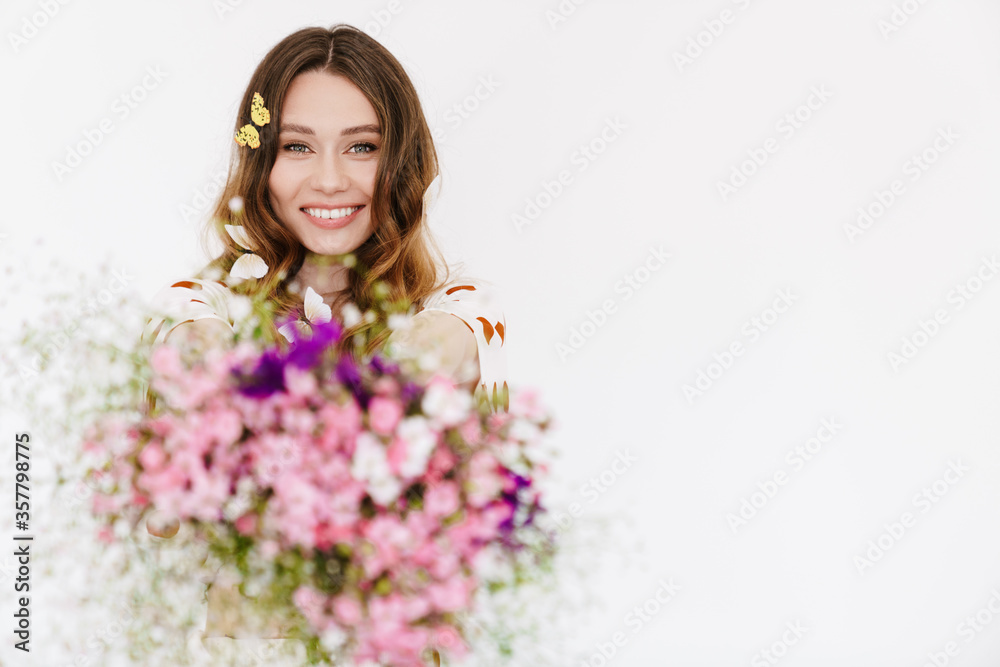 Wall mural Photo of smiling woman with fake butterflies showing flowers at camera