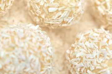 close-up, candies covered by shredded coconut. coconut balls with coconut flakes. top view
