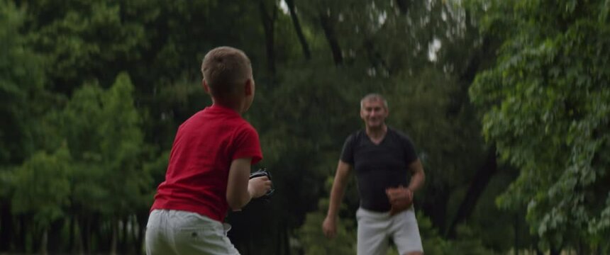 WIDE Father and son playing baseball catch in the park. Family time spent together. Shot with 2x Anamorphic lens