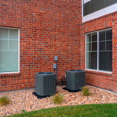 Obraz premium Square Corner brick wall to a building with two bins