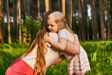 little girl hugs her mom outdoors