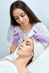 Obraz na płótnie Canvas Attractive woman is getting rejuvenating facial injections in beauty salon. Cosmetology concept.