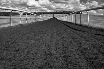 Monochrome image of a horse gallop track in a large open space in rural Britain.