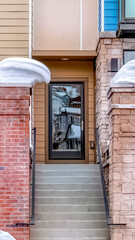 Vertical crop Stairs and glass door of residential building with brick fence and balconies