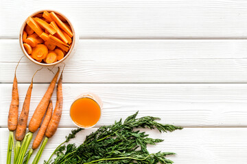 Sliced carrot and juice on wooden table top view copy space