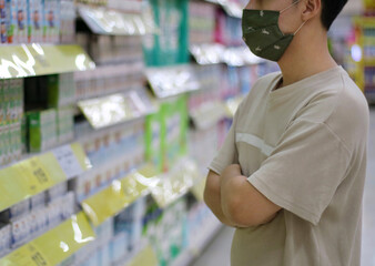 Shopping, A man wearing mask choosing drinking products or foods alone(Social distancing) for quarantine at supermarket
