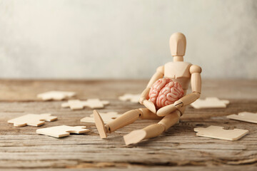 Toy man sits depressed with a puzzle. Despair and desolation. Confusion in itself, perplexity.