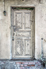 An old wooden door with peeling paint, padlocked