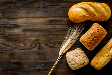 Homemade bread and ears on wooden background top view copy space