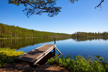 Very beautiful lake landscape in Finland. There is also a wooden pier in the photo.