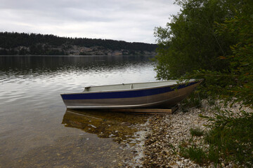 A boat waits on the shore of the lake