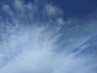 Ant's eye view of white clouds moving with blue sky background.