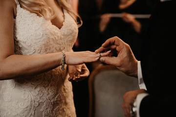 Obraz na płótnie Canvas the groom wears the ring to the bride
