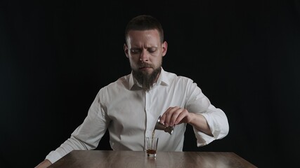 The bartender pours coffee liqueur from jigger to cocktail glass