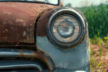 Fototapeta na wymiar Headlamp of Old retro rusty abandoned car, close up.