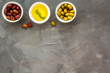 Olive oil in bowl near oilves from above copy space