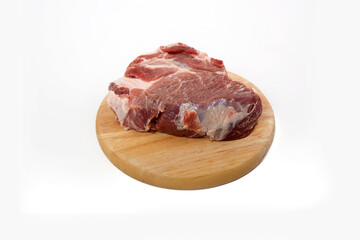a piece of raw meat pork on a wooden backing