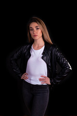 A young girl in a black leather jacket isolated on a black background