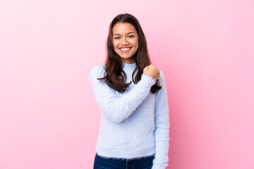 Young Colombian girl over isolated pink background celebrating a victory