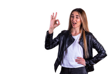 The girl in the leather jacket gestures OK. Isolated on a white background