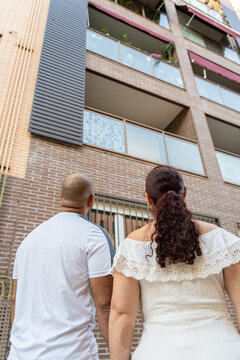 Couple Looking Up Saying Hi To Neighbors And Family