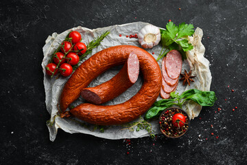 Smoked sausage ring with spices and herbs. Top view. Free space for text.