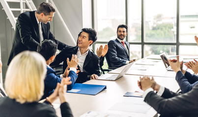 Businessman speaker presentation and discussing meeting strategy sharing ideas thoughts.Creative work group of casual business people clapping hands in modern office.Success concept